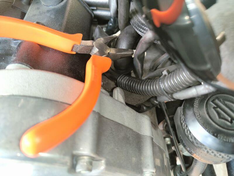 ペンチでホースを引っ張る様子